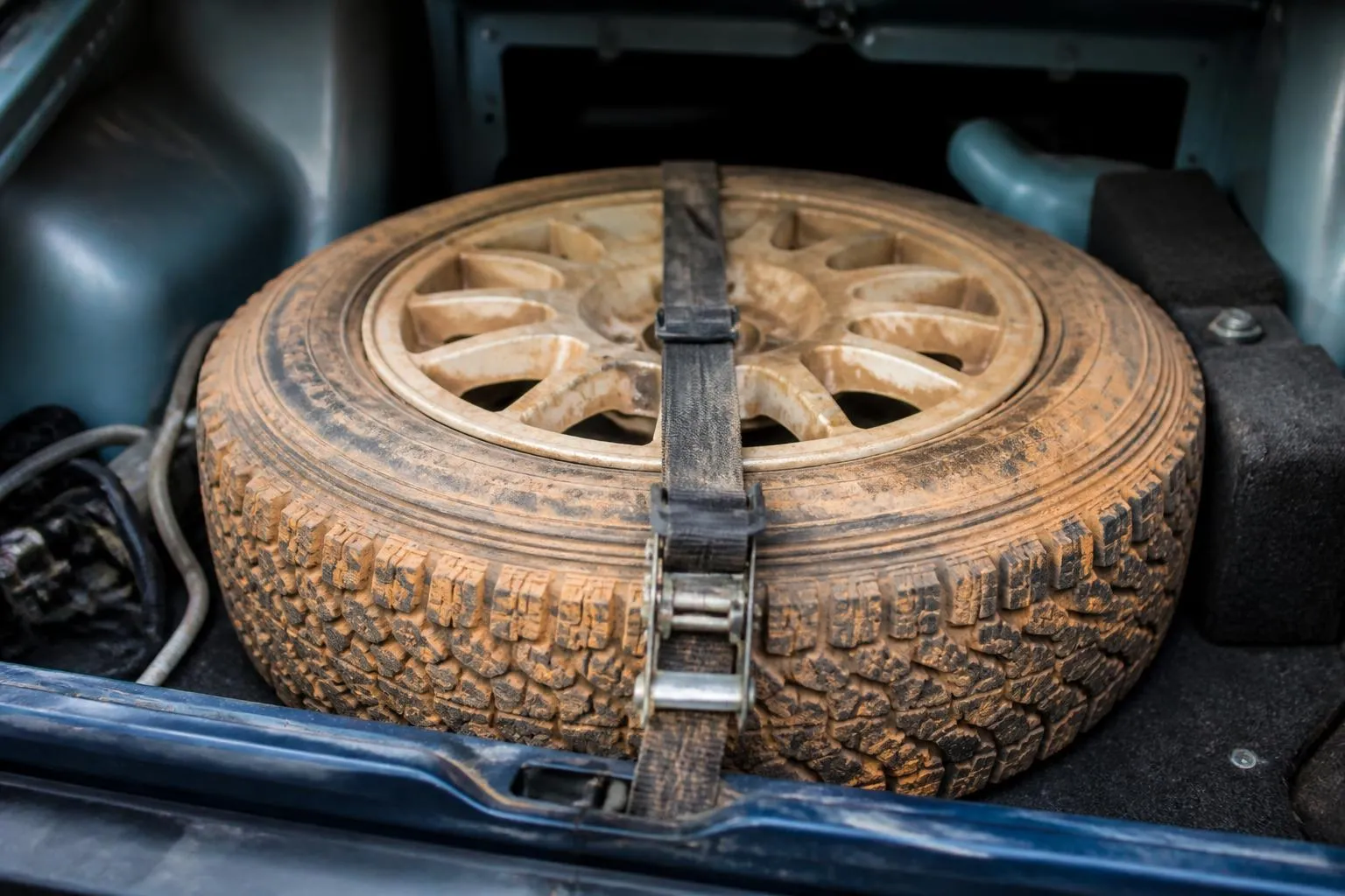 Roue de rallye sanglee dans un coffre